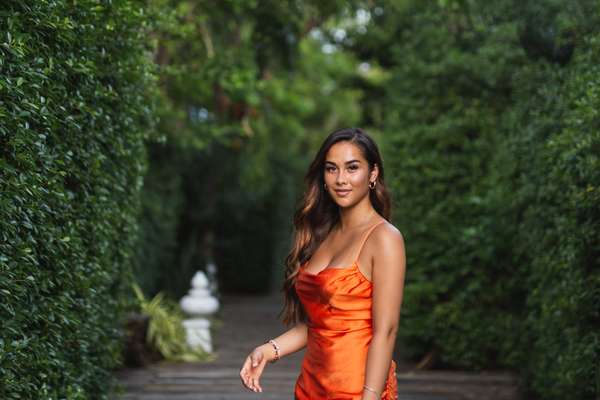 a woman in an orange dress outside