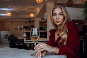 a woman with a glass of wine in a restaurant