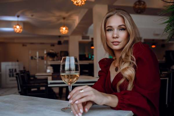 a woman with a glass of wine in a restaurant