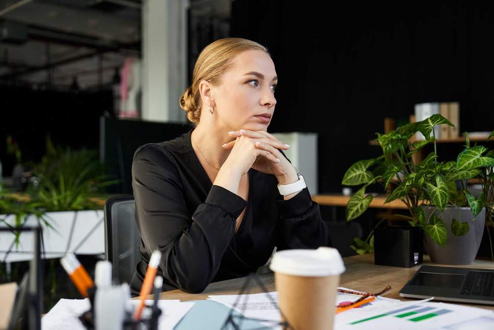 A young beautiful plus size woman focuses intently while working at her office desk.