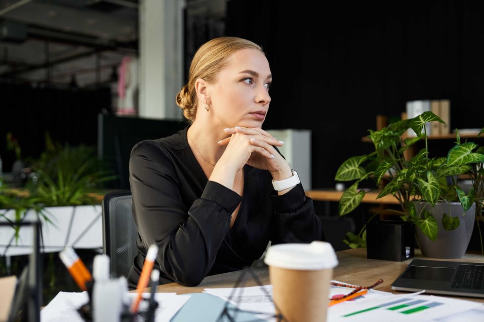 A young beautiful plus size woman focuses intently while working at her office desk.