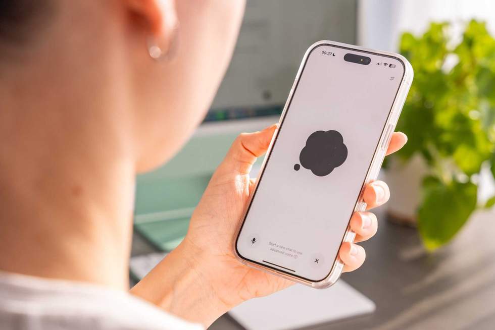 Back view of woman holding Iphone with Chat Gpt application on screen. Work assistant with Open Ai. Artificial Intelligence concept. High quality photo