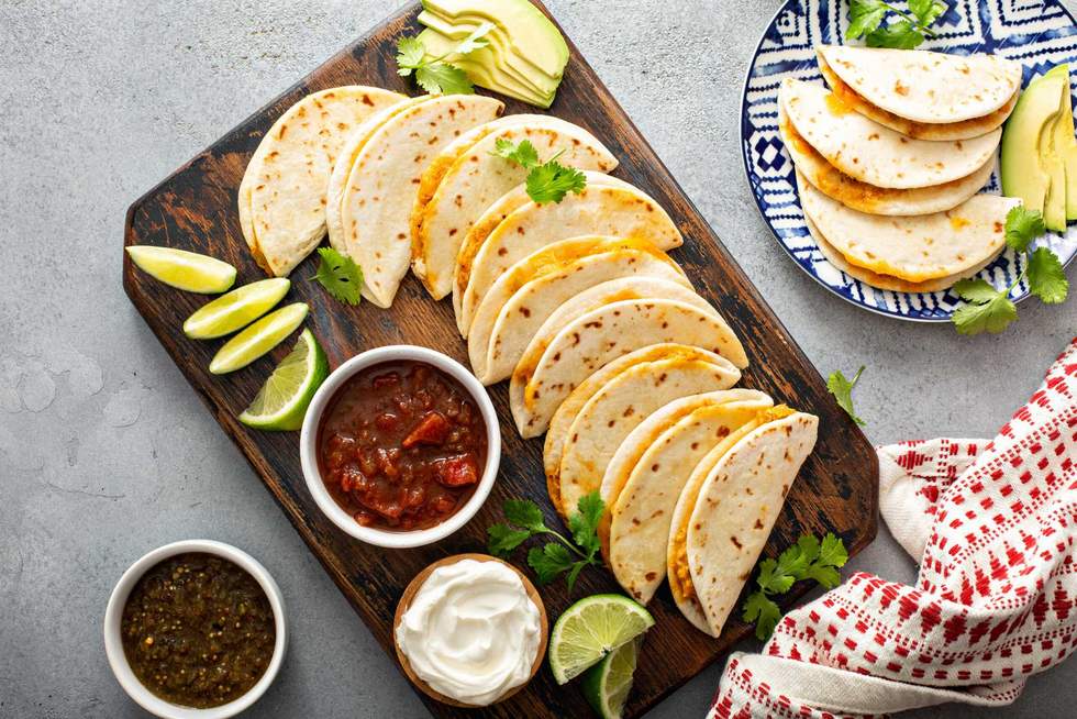Baked tacos with pulled chicken and cheese served with sour cream and salsa