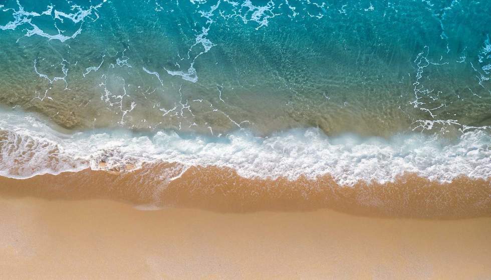 Beach Sand Sea Shore with Blue wave and white foamy summer background, Aerial beach top view overhead seaside.