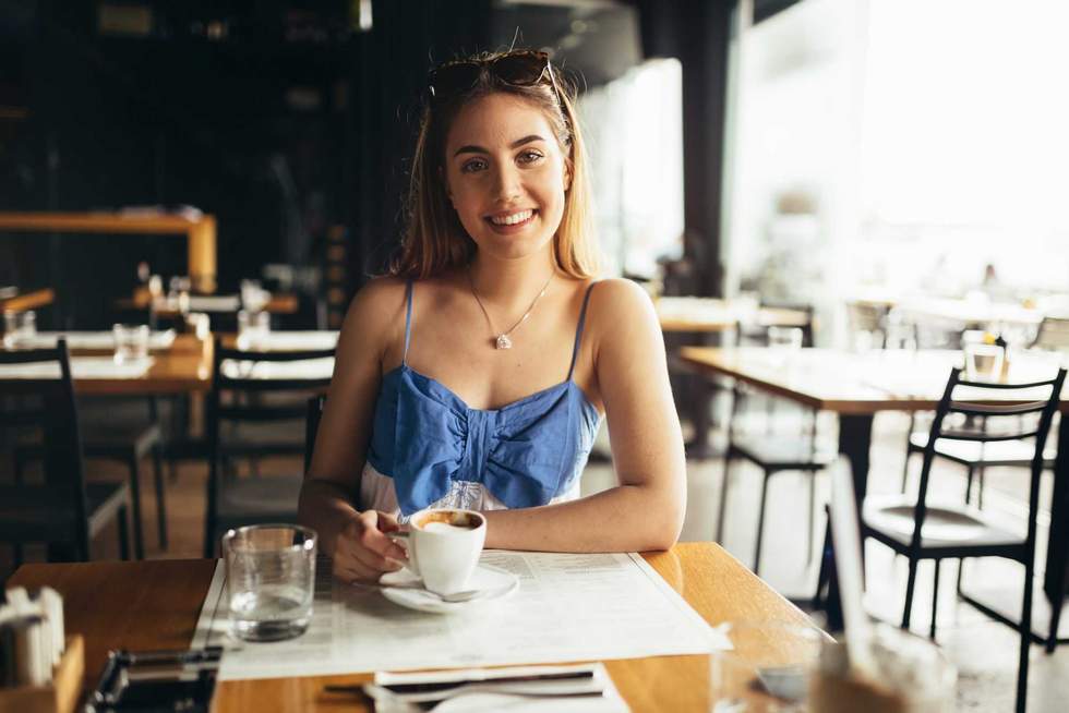 Beautiful woman drinking coffee in restaurant