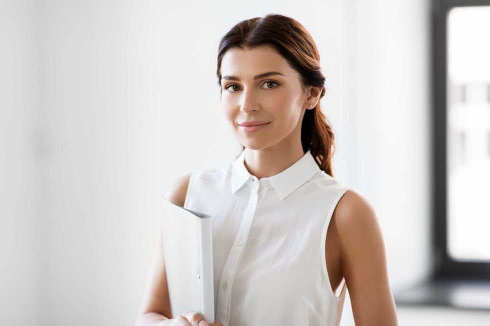 business, people and corporate concept - businesswoman or realtor with folder at office