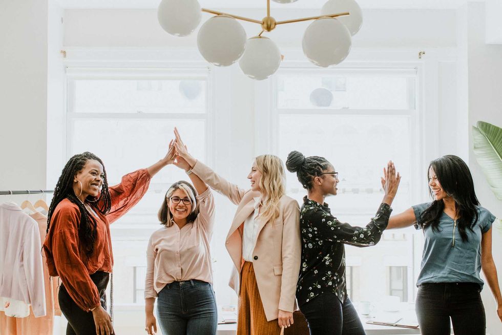 Businesswomen giving a high five to team