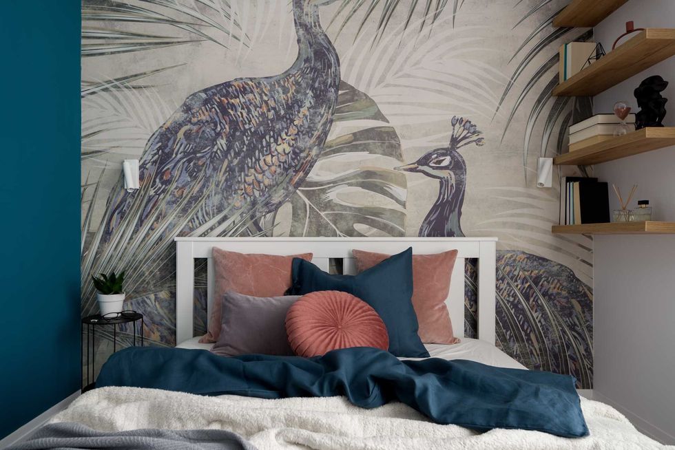 Charming and nice decorated bedroom with big bed with stylish bedclothes and beautiful wallpaper