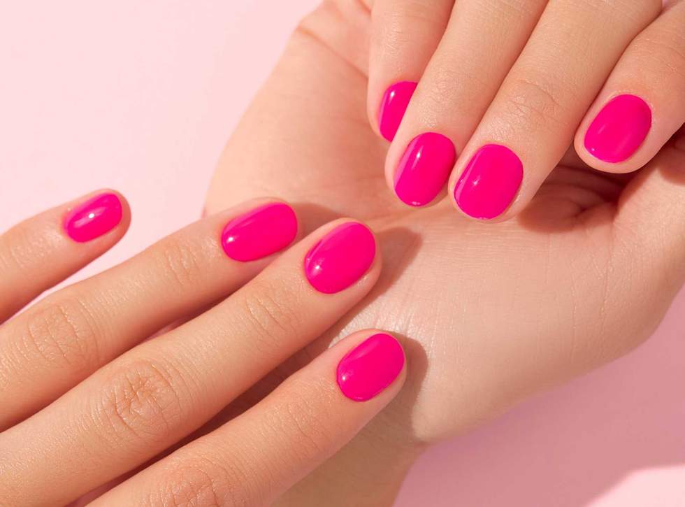 Close up beautiful womans hands with pink nail design. Manicure, pedicure beauty salon concept. Trendy color