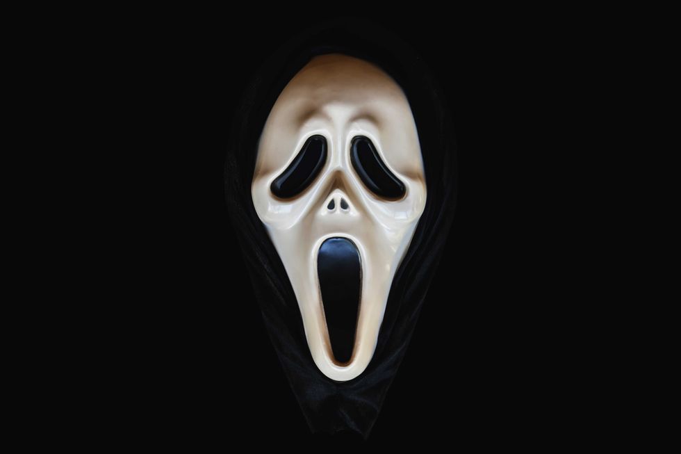 Close-up of screaming carnival mask object on a black background