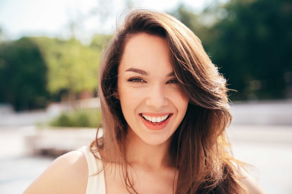Closeup portrait of young beautiful smiling woman in trendy.