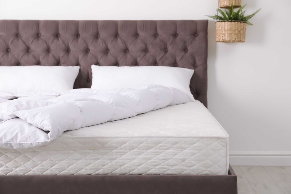 Comfortable bed with new mattress in room. Healthy sleep