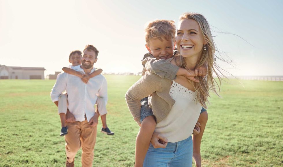 Family, kids and piggy back at park, nature or outdoors on vacation, holiday or summer trip. Love, support and caring parents, man and woman bonding with boys, carrying and enjoying fun time together.