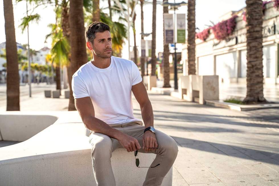 Handsome young man wearing white tshirt posing on city street background. Casual style. Fashionable guy. Summer vibes.
