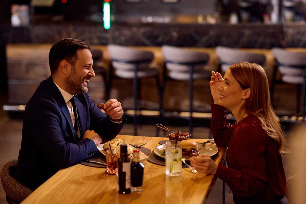 Happy business couple having fun while having lunch in restaurant.