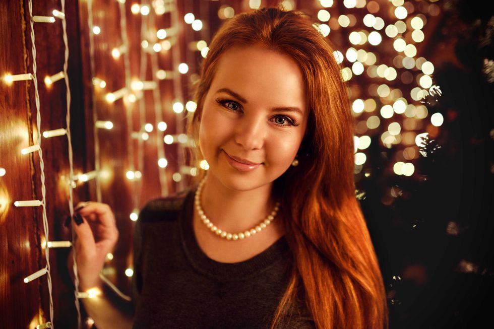 Happy red haired woman posing in christmas decoration