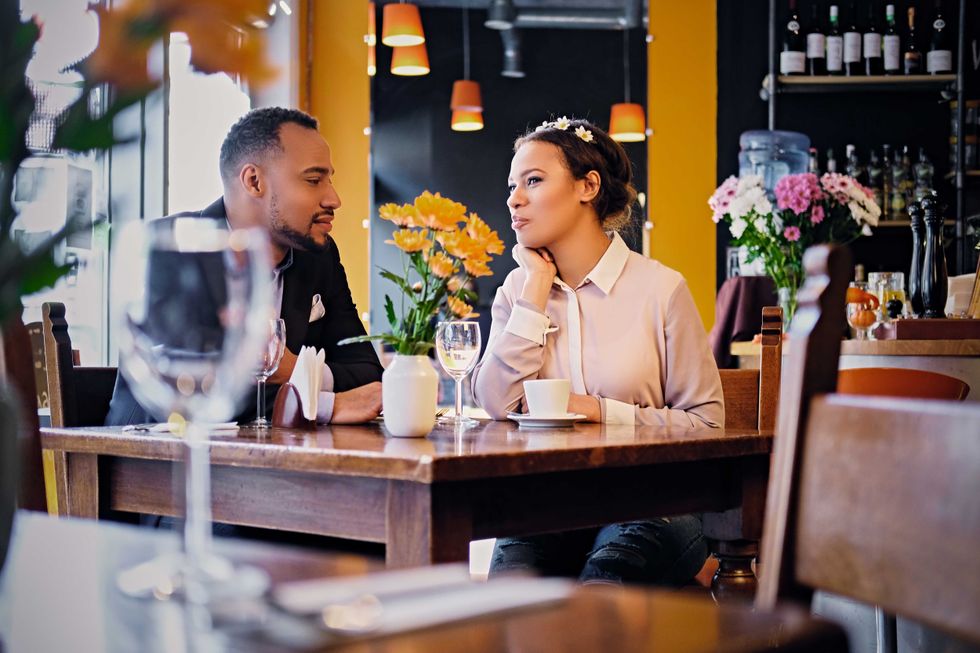 Loving black American couple on a date drinking wine in a restaurant.