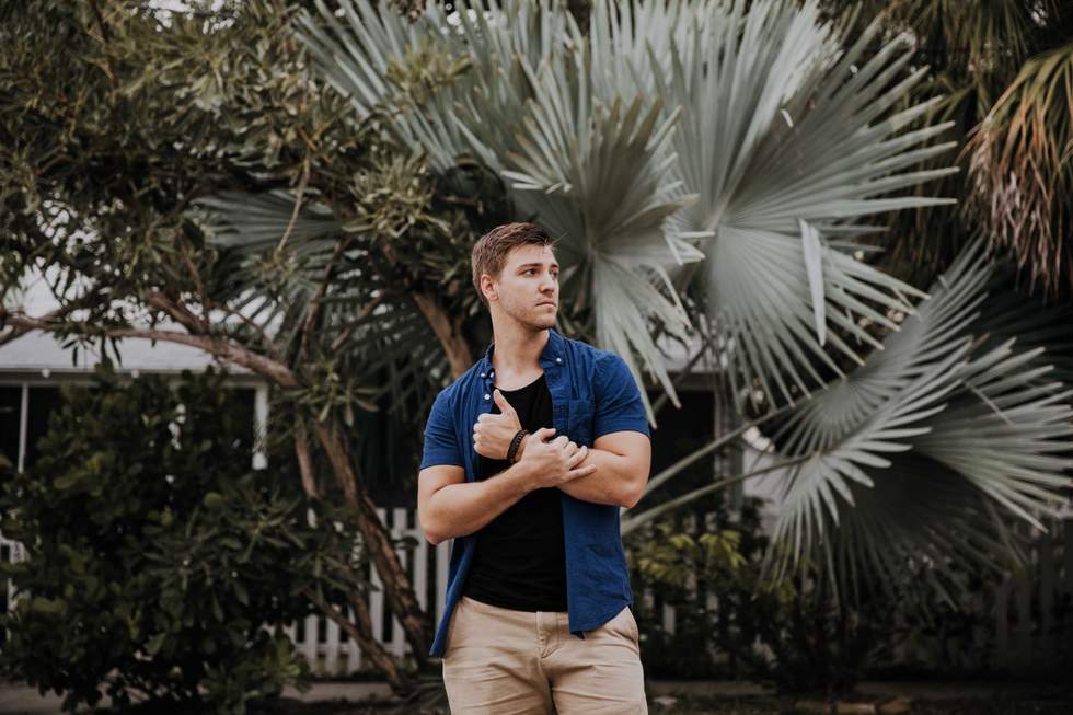 man standing in front of a palm tree