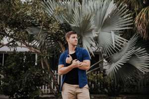 man standing in front of a palm tree