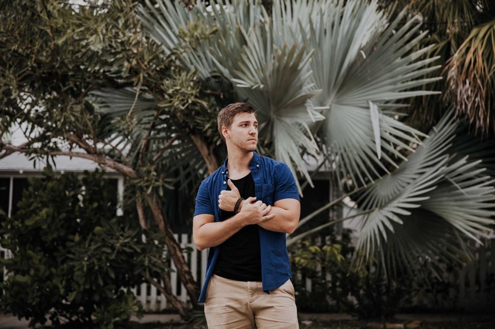 man standing in front of a palm tree