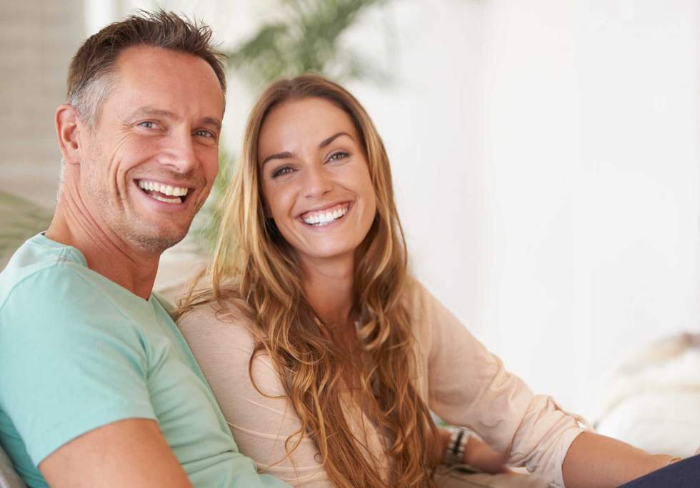 Portrait of a happy couple smiling at you.