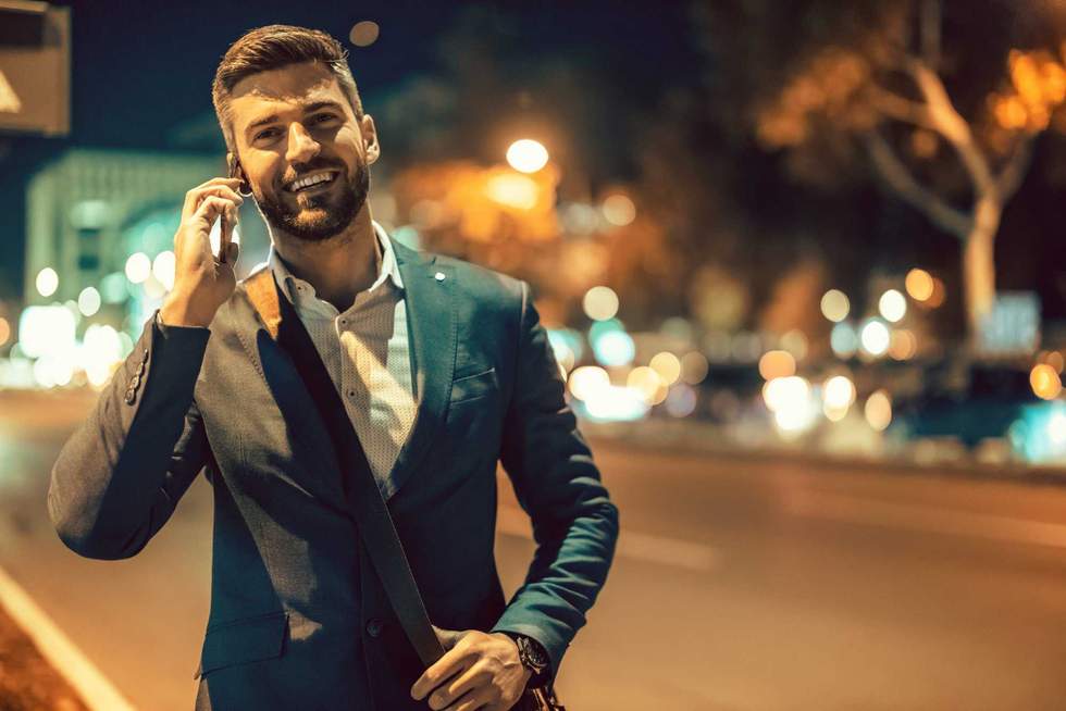 Portrait of businessman outdoors,he is using smart phone.Trying to help someone.