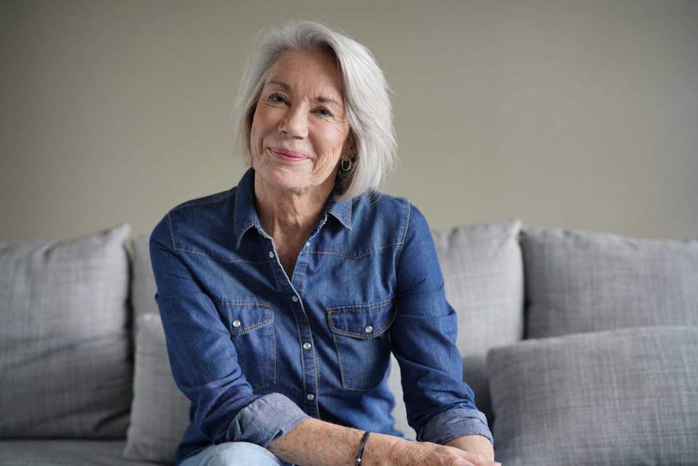 Portrait of modern senior woman in all denim on couch