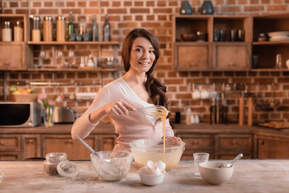 portrait of smiling woman mixing ingredients for cake