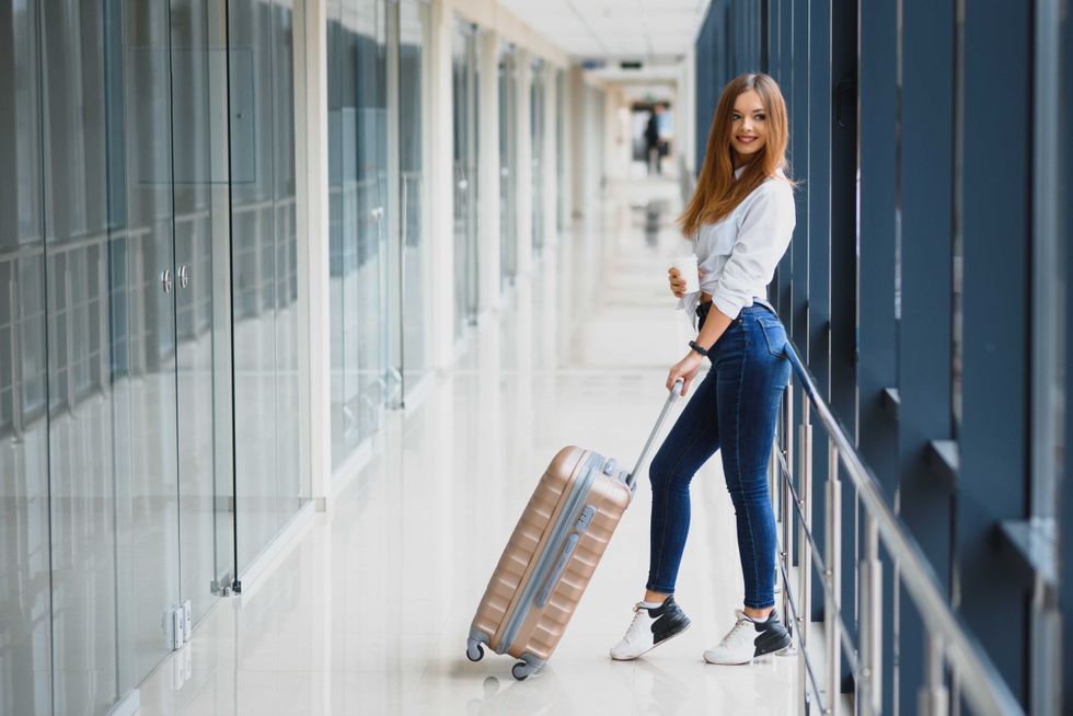 pretty girl with a suitcase in the airport terminal. vacation and travel concept