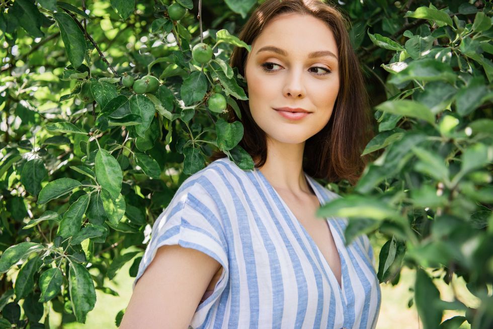 Pretty woman standing near tree branches outdoors