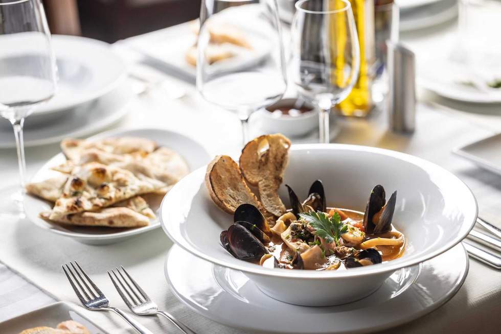 Seafood and fish soup served in an Italian restaurant in a fancy setting.
