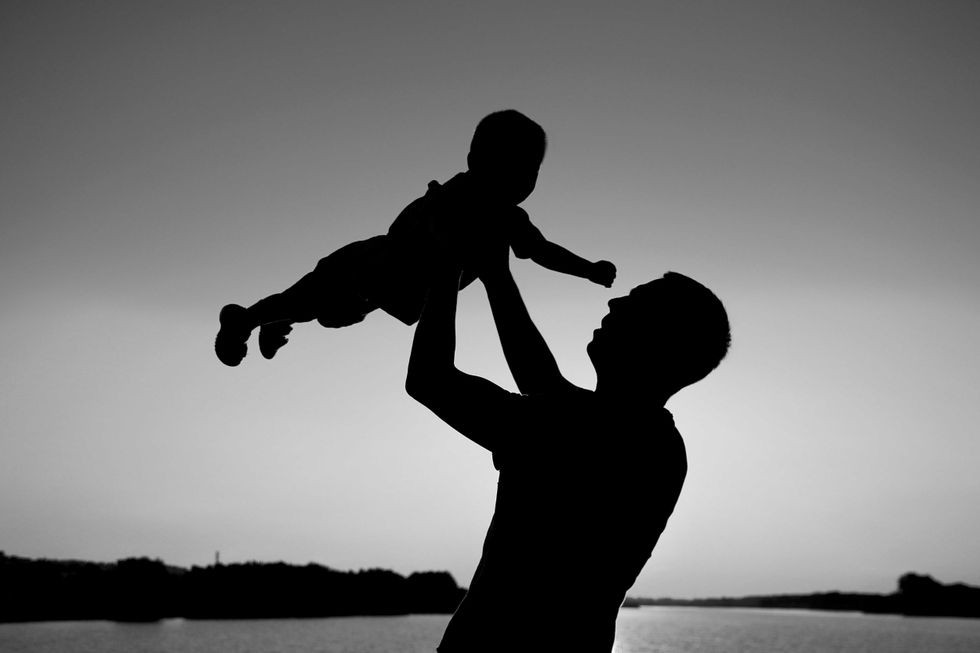 silhouette of father and son play on sunset