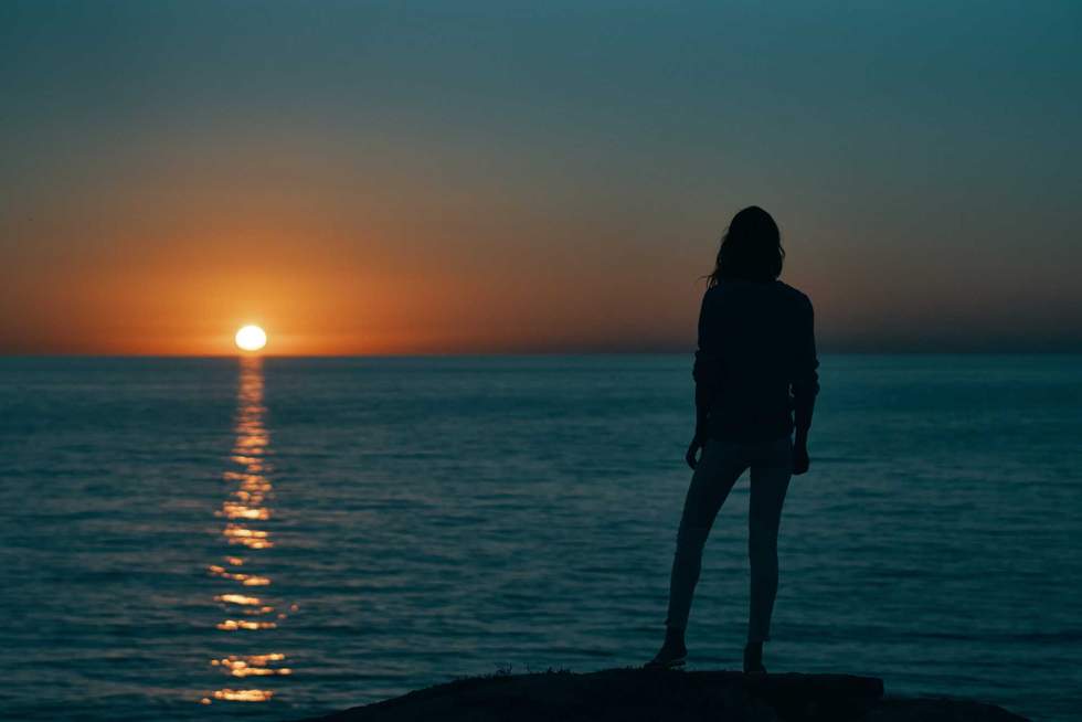 silhouette of woman on the sea at sunset and skyline beach sky. High quality photo