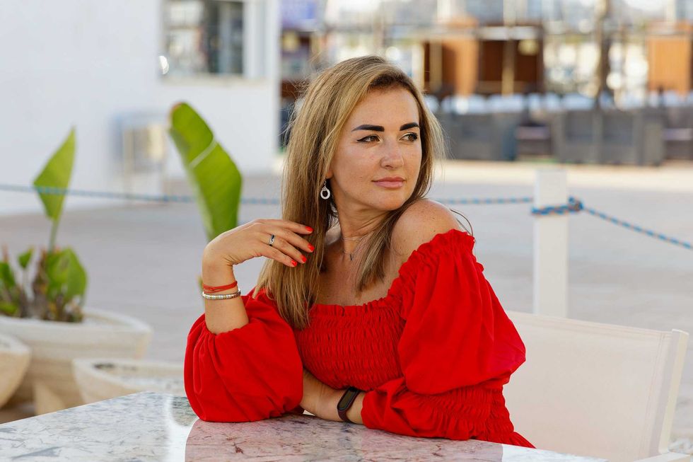 Stylish beautiful woman in a red dress in a cafe