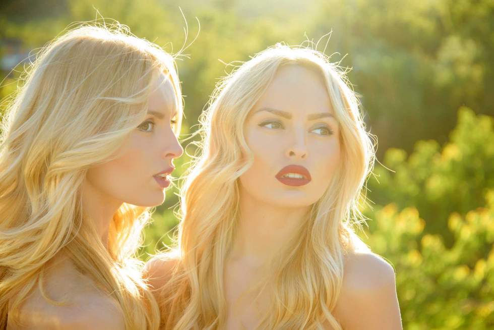 Twins in summer sunny weather. Beauty and fashion, look. Girls with sexy red lips, family and sisters. Freedom, relations and family values. Women with blonde hair and makeup outdoor.