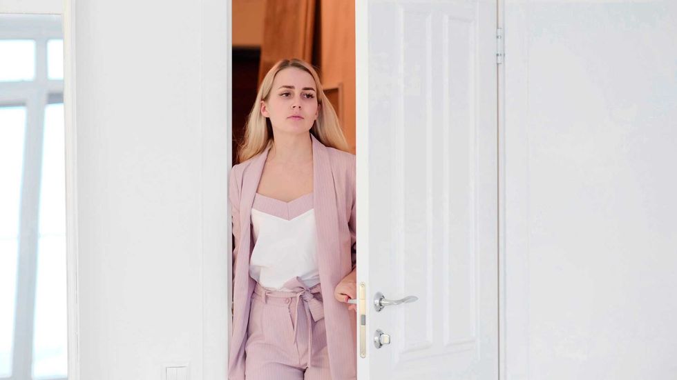 Woman opening door. tired woman enters a room or her apartment after a hard day at work
