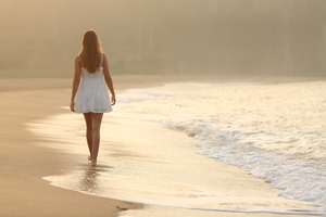 Woman walking on the sand of the beach
