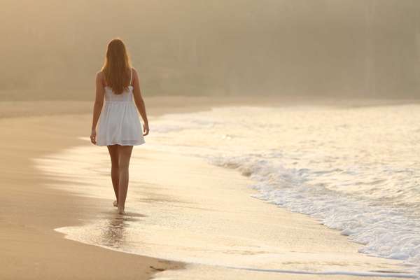 Woman walking on the sand of the beach