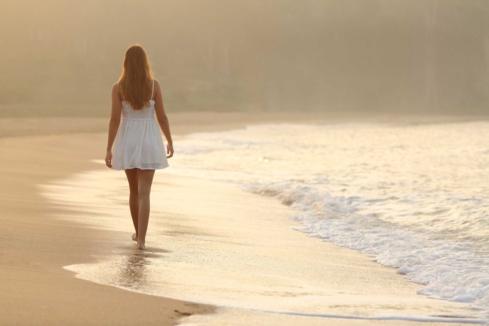 Woman walking on the sand of the beach