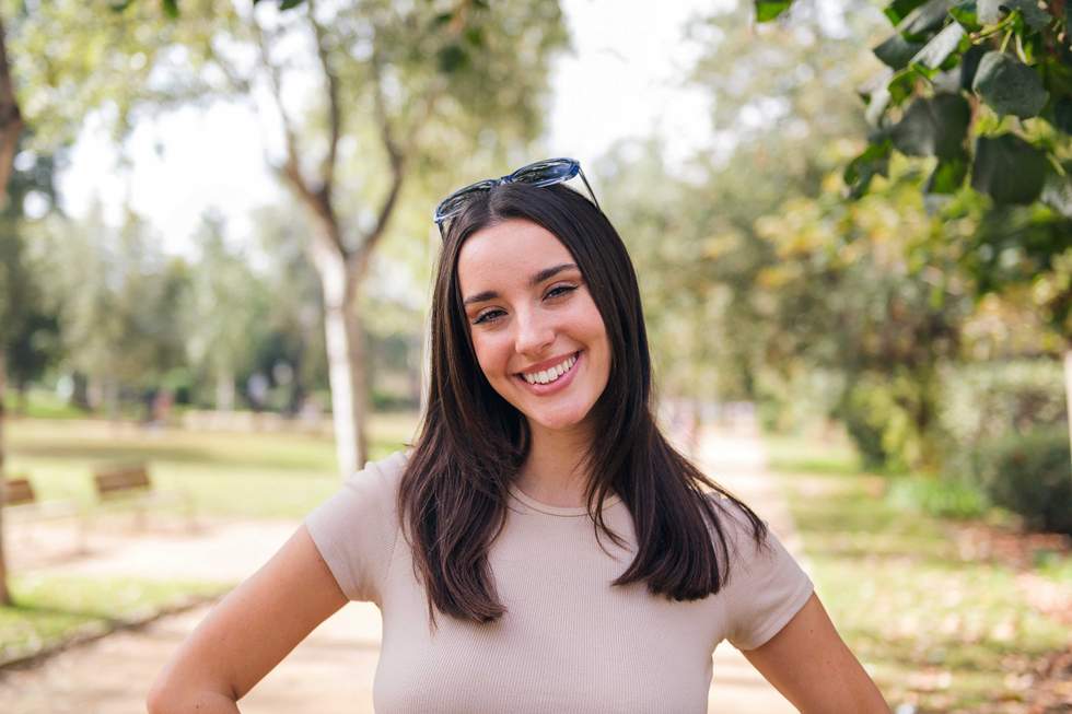 young caucasian woman looking at camera smiling with sunglasses on her head, concept of youth and beauty