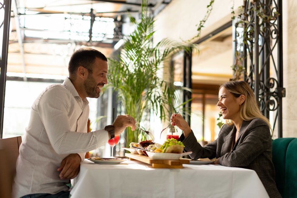 Young couple having a lunch and drinking fresh squeezed juice in the restaurant