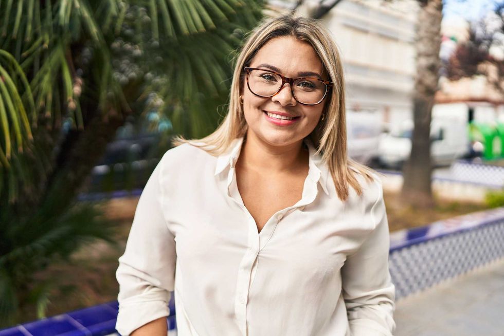 Young hispanic woman smiling confident standing at park
