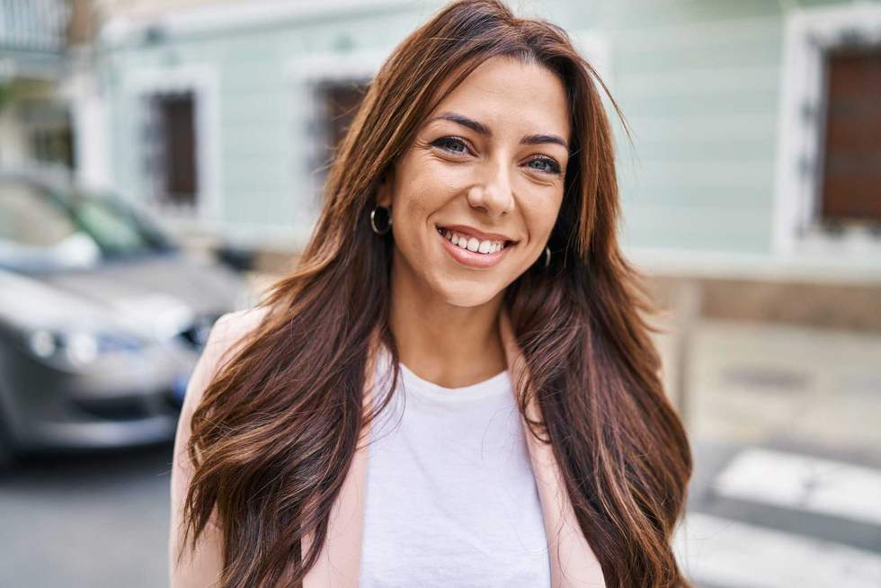 Young hispanic woman smiling confident walking at street