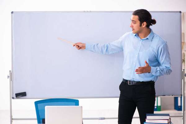 Young male teacher in front of whiteboard