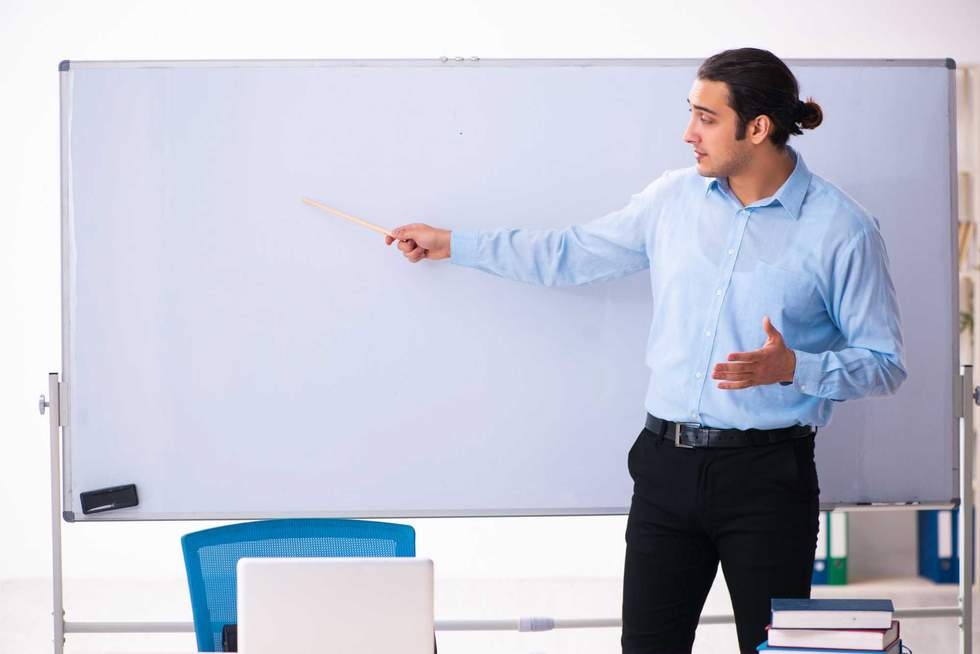 Young male teacher in front of whiteboard