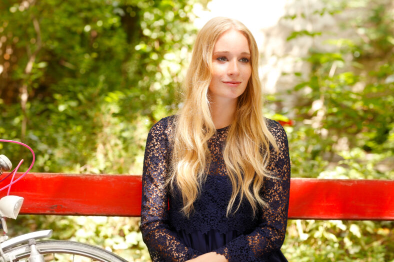 Close-up portrait of beautiful young woman sitting at park.