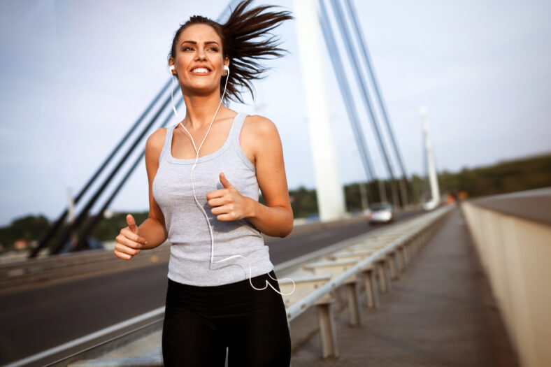 Pretty female jogger running and staying active