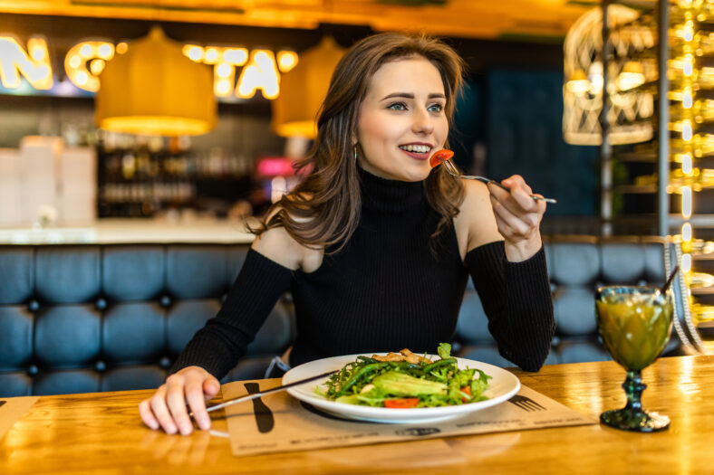 Happy woman eating lunch in restaurant
