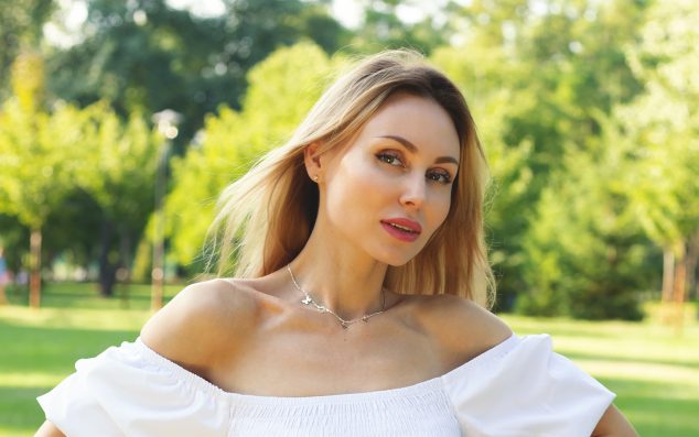 Summer portrait of a beautiful model against the park