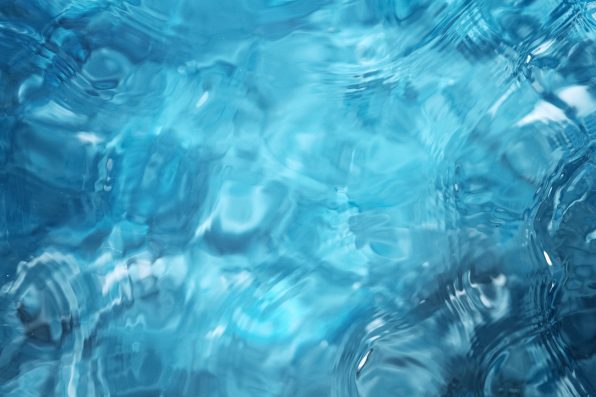 Blue water surface background, studio shot, texture of splashing abstract water shape